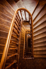 Wooden staircase - view from above.   Perspective view of clockwise U-shaped staircase in an old...