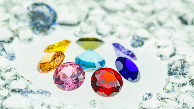 .colorful gems displayed in the middle of a white diamonds..light pendant shine on diamonds..beautiful colored diamonds surrounded by white diamonds..beautiful diamonds turning around. studio shoot.