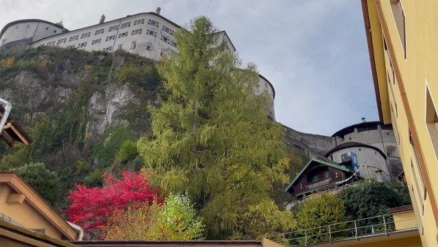 Kufstein Fortress on top of hill and funicular going down on sunny day with colorful trees in autumn season in Austria. Tyrol landmark, cultural trip concepts