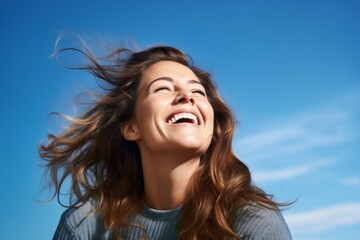 Lifestyle portrait photography of a grinning girl in her 30s laughing against a sky-blue background. With generative AI technology