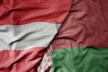 big waving national colorful flag of austria and national flag of belarus .