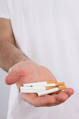 Concept of addiction to smoking, pile of cigarettes in the hands of a man.