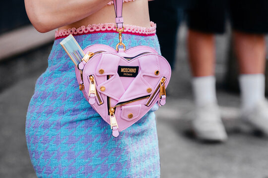 Milan, Italy - June, 19, 2022: woman wears pink heart biker bag from Moschino, street style accessories.