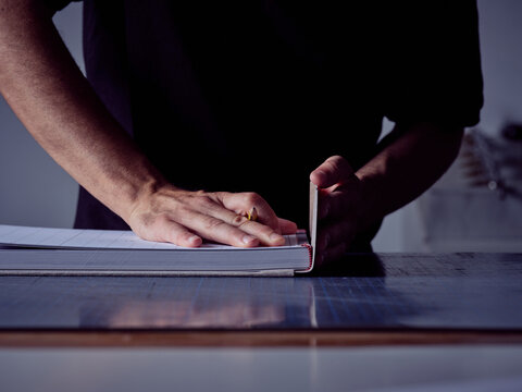 Faceless man making book cover while working at workshop