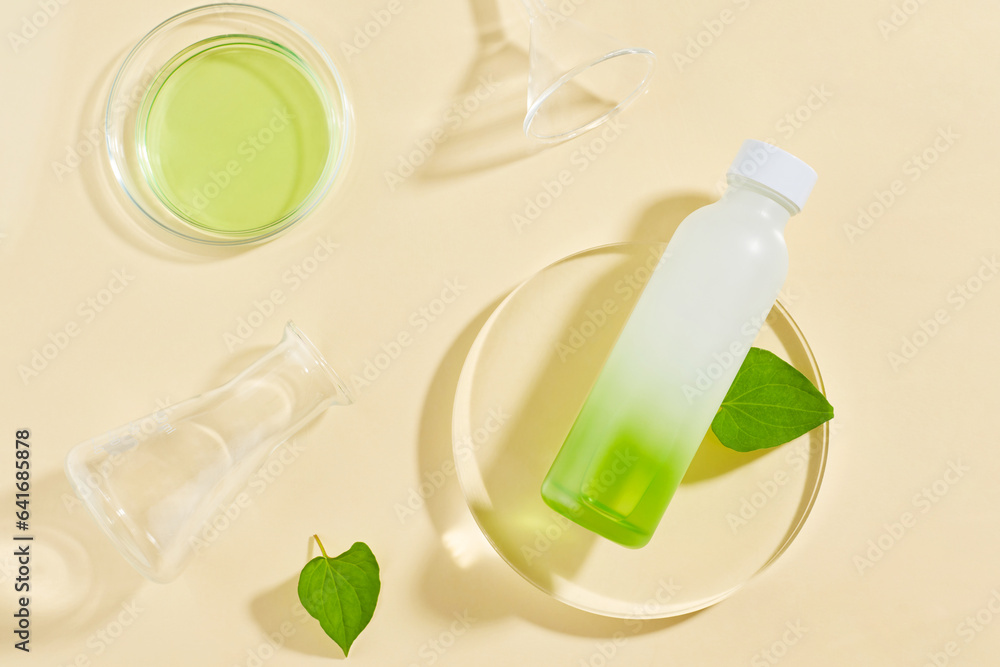 Poster Blank label bottle put on transparent podium, displayed with laboratory glassware. Fish mint (Houttuynia cordata) can strengthen immune systems