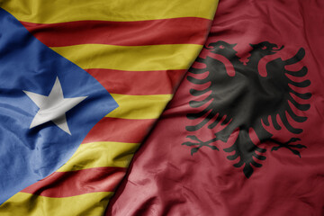 big waving national colorful flag of catalonia and national flag of albania .