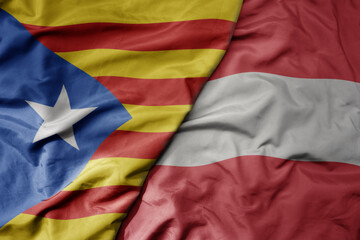 big waving national colorful flag of catalonia and national flag of austria .