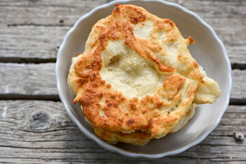 Traditional Bulgarian home made deep fried  patties  covered with sugar  оn rustic backgroud.Mekitsa or Mekica,  on wooden  rustic  background. Made of kneaded dough that is deep fried 