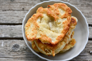 Traditional Bulgarian home made deep fried  patties  covered with sugar  оn rustic backgroud.Mekitsa or Mekica,  on wooden  rustic  background. Made of kneaded dough that is deep fried 