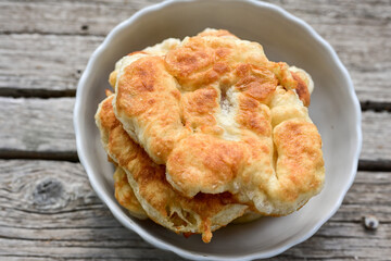 Traditional Bulgarian home made deep fried  patties  covered with sugar  оn rustic backgroud.Mekitsa or Mekica,  on wooden  rustic  background. Made of kneaded dough that is deep fried 