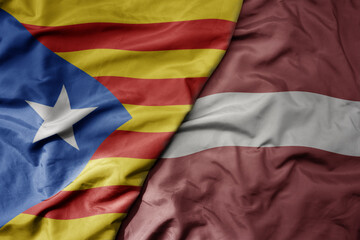 big waving national colorful flag of catalonia and national flag of latvia .