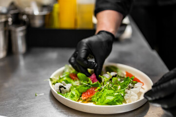 chef hands cooking Fresh sashimi salad with salmon fish, tuna and vegetables on kitchen