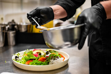 chef hands cooking Fresh sashimi salad with salmon fish, tuna and vegetables on kitchen
