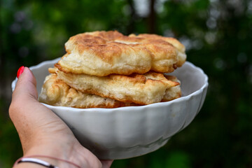 Traditional Bulgarian home made deep fried  patties  covered with sugar  оn rustic backgroud.Mekitsa or Mekica,  on wooden  rustic  background. Made of kneaded dough that is deep fried 