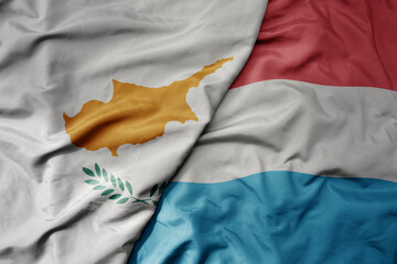 big waving national colorful flag of cyprus and national flag of luxembourg .