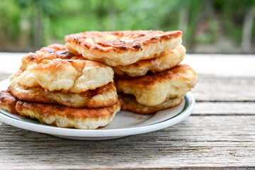 Traditional Bulgarian home made deep fried  patties  covered with sugar  оn rustic backgroud.Mekitsa or Mekica,  on wooden  rustic  background. Made of kneaded dough that is deep fried 