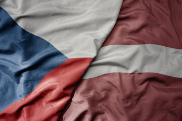 big waving national colorful flag of czech republic and national flag of latvia .