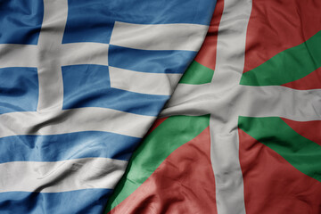 big waving national colorful flag of greece and national flag of basque country .