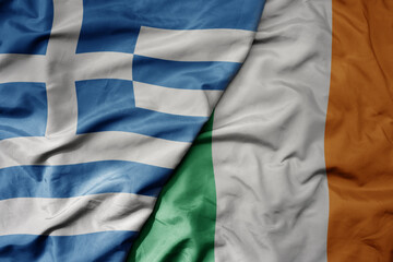 big waving national colorful flag of greece and national flag of ireland .
