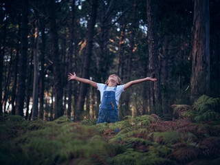 Boy with outstretched arms in nature