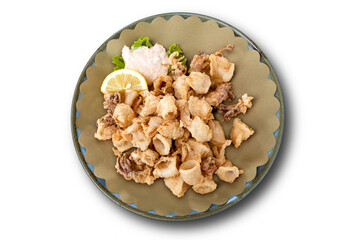 Round dish with fried squid with sauce and lemon wedge