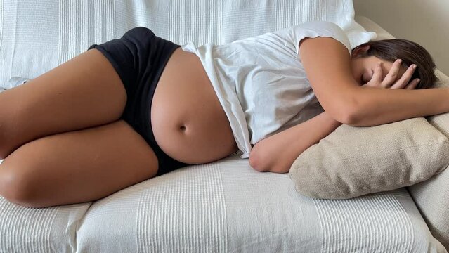 Pregnant woman lying on the sofa resting. Pregnancy concept