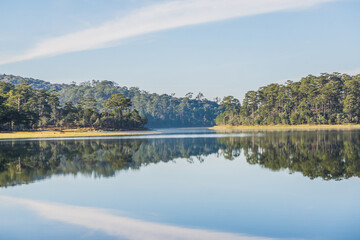 Fototapeta premium The quiet lake surface reflects the clouds and mountains into Tuyen Lam Lake