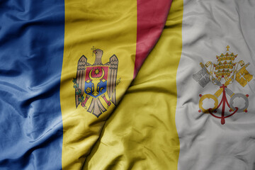 big waving national colorful flag of moldova and national flag of vatican city .