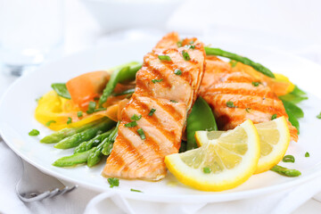 Exquisite Grilled Salmon Fillet Served with Fresh Asparagus Spears and Lemon Wedges on a White Plate: A Gourmet Culinary Experience Ideal for Fine Dining and Healthy Lifestyle