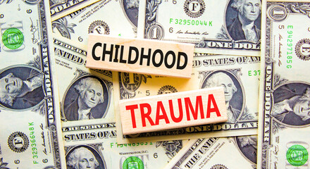 Childhood trauma symbol. Concept words Childhood trauma on beautiful wooden blocks. Dollar bills....