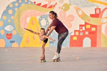 Little sport girl with trainer practicing roller skating