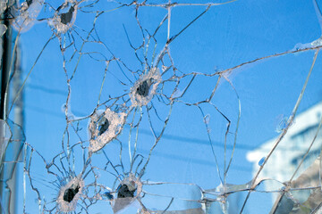 Bullet holes in blue glass