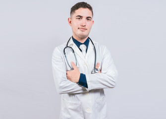 Portrait of handsome doctor with arms crossed isolated. Latin doctor with crossed arms on white background.