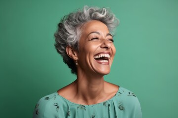 Headshot portrait photography of a happy mature woman winking against a spearmint green background. With generative AI technology