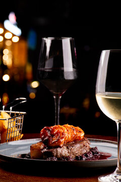 dinner table for two with two glasses of surf and turf white wine with blackberry jam in focus