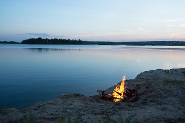 campfire on the lake shore at sunset