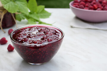 Raspberry jam with berry on light background. Homemade jam with raspberry. Banner, menu, recipe. Side view, place for text.