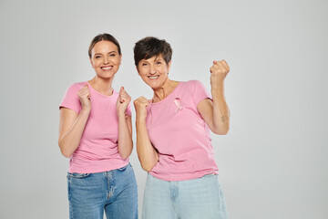 breast cancer concept, excited women looking at camera and gesturing on grey backdrop, yes, yay