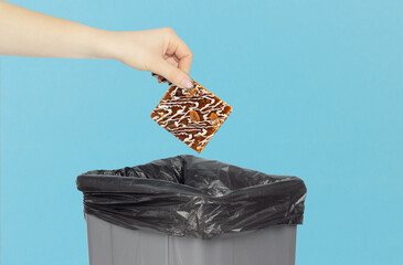 Throw cake into the trash can, cake in hand in front of the trash can, the concept of throwing away...