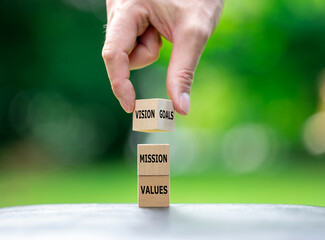 A stack of wooden cubes sow the words values, mission, vision and goals.