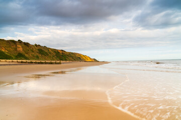 Tide receding at an empty beach in Mundesley, North Norfolk UK at sunrise