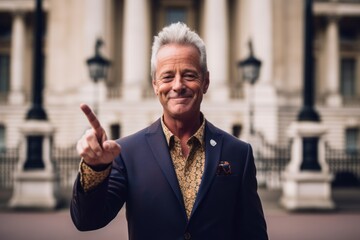 Environmental portrait photography of a content mature man flashing a v for victory sign donning a bold statement necklace at the buckingham palace in london england. With generative AI technology - obrazy, fototapety, plakaty