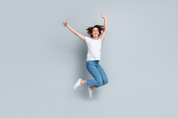 Fototapeta na wymiar Full length photo of crazy cheerful person have good mood raise hands jumping flying isolated on grey color background