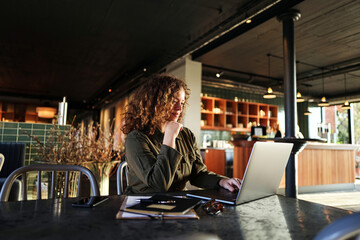 Smiling businesswoman working online with a laptop at a table