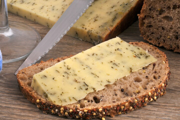 Morceau de tomme ail des ours sur une tranche de pain aux graines en gros plan