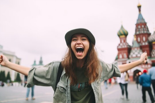 Medium shot portrait photography of a cheerful girl in her 20s shaking fist sporting a practical bucket hat at the red square in moscow russia. With generative AI technology