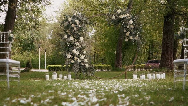 Beautiful wedding arch in flowers of white roses before the wedding ceremony, rose petals	