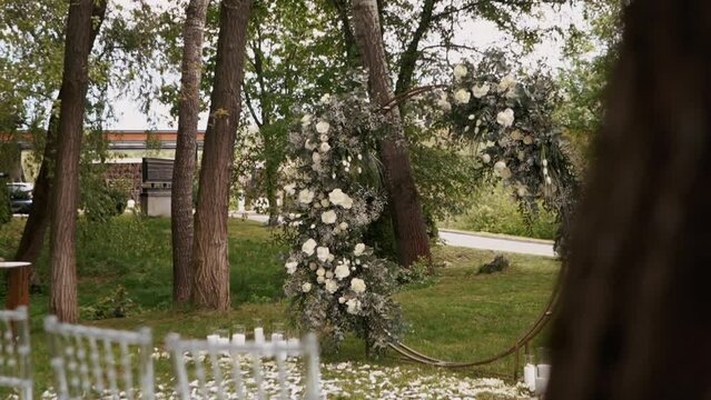 Beautiful wedding arch in flowers of white roses before the wedding ceremony, rose petals	