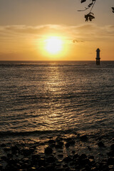 Fototapeta premium sunset view at senggigi lombok beach with the silhouette of mount agung bali, sunset over the sea, sunset at the beach, sunset and mountain, lighthouse at sea, sunset on the sea, senggigi lombok