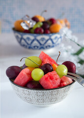 cup with cold water and fresh summer fruit with ice